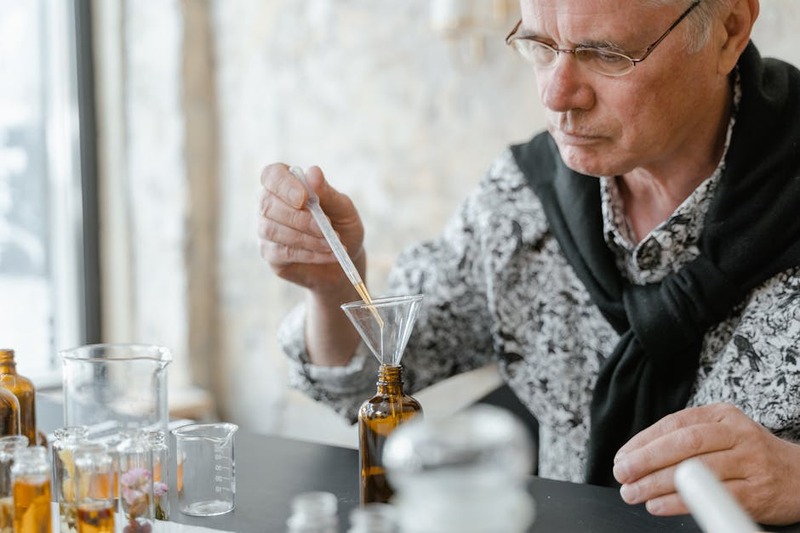 Een jonge alchemist in een bos, omringd door gloeiende planten en vreemde dieren.