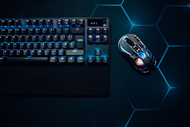 Een SteelSeries Aerox 9 Wireless gaming muis met een geperforeerd ontwerp en veel zijtoetsen, ideaal voor MMO's.
