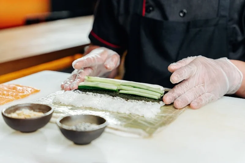 Chef bereidt verse sushi rollen in een moderne keuken